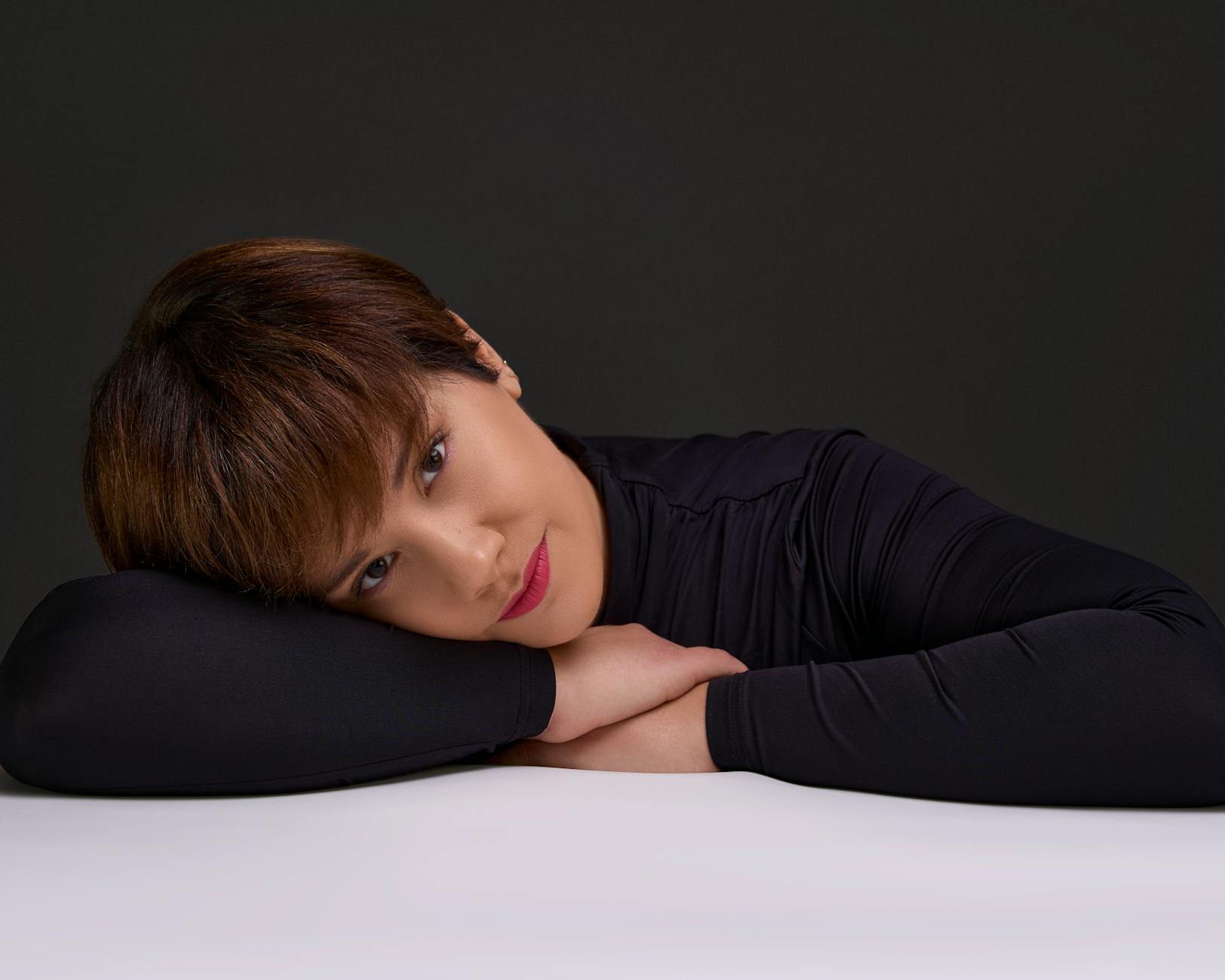 artistic portrait of woman resting on table