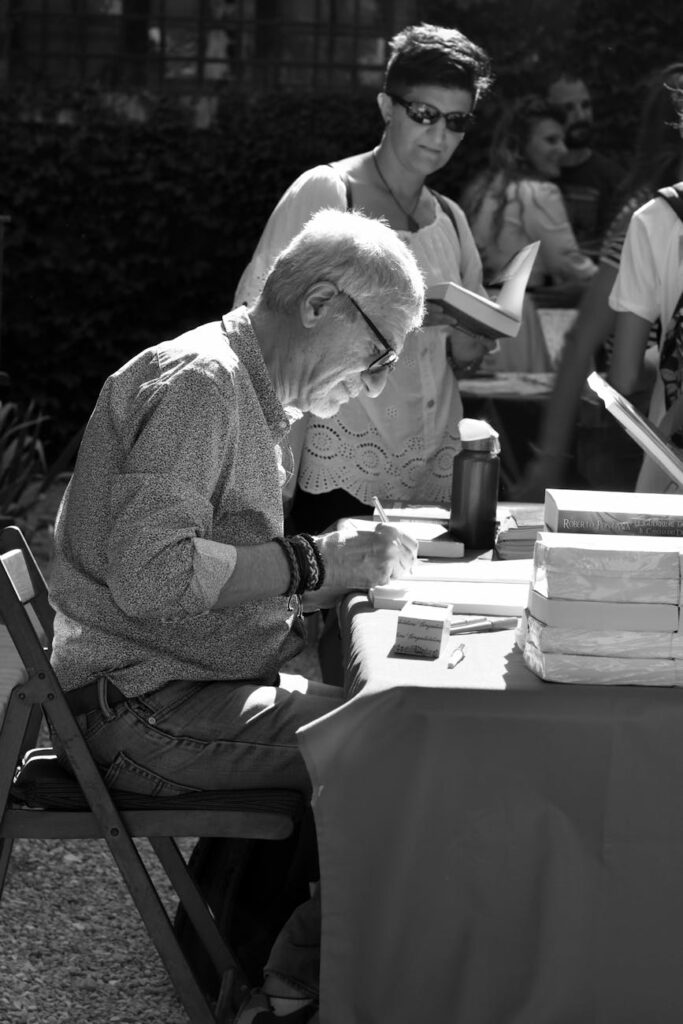 elderly man signing the books
